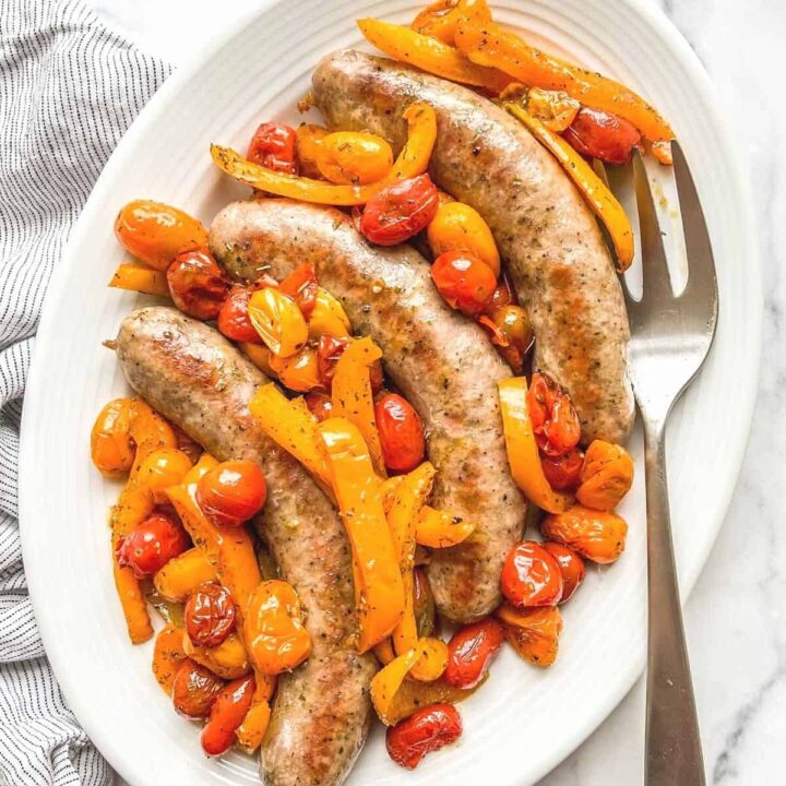 Oven baked Italian sausage with tomatoes and bell peppers.