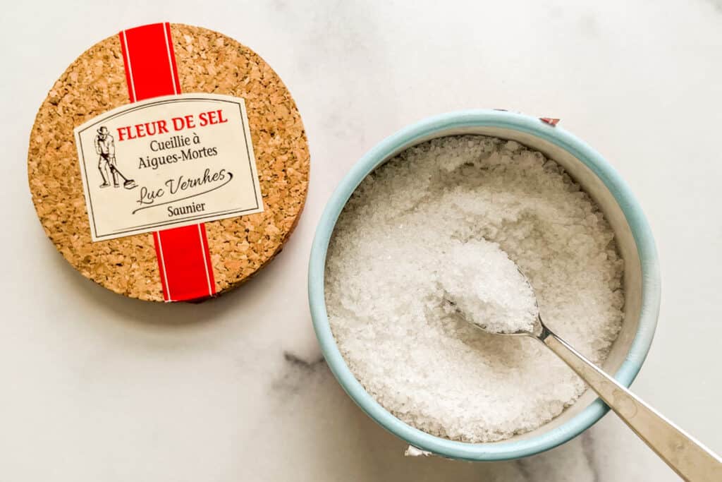 Fleur de Sel in a container with a spoon.