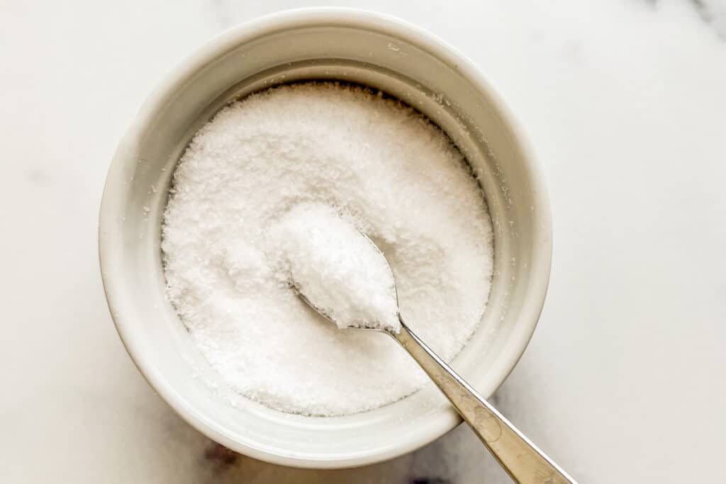 Kosher salt in a white ramekin with a spoon.