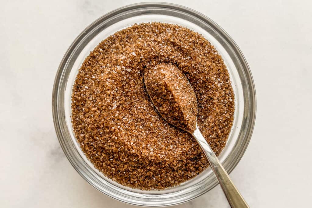 Smoked salt in a small glass bowl with a spoon.