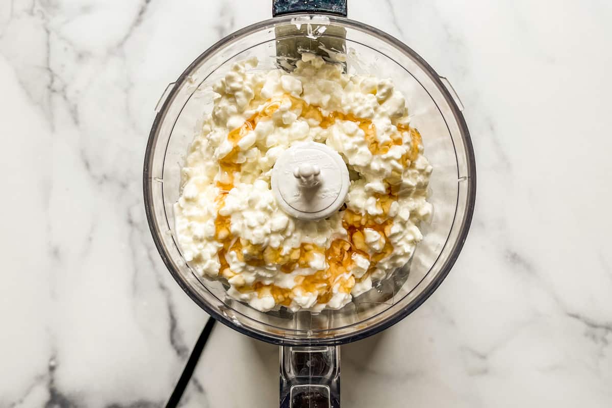 Cottage cheese and honey in a small food processor.