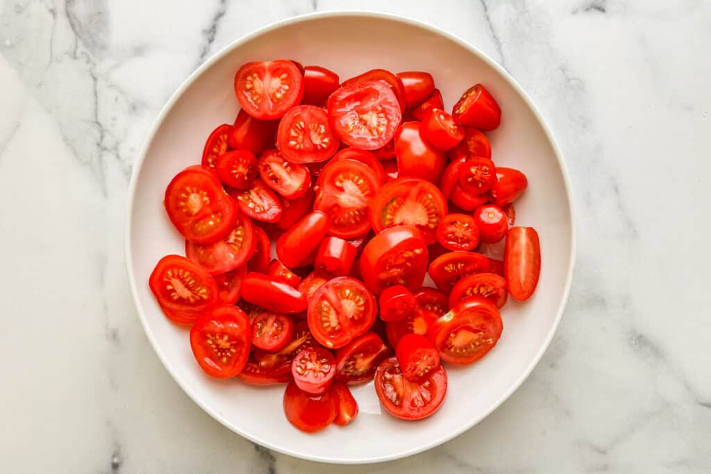 Sliced tomatoes in a large white bowl.