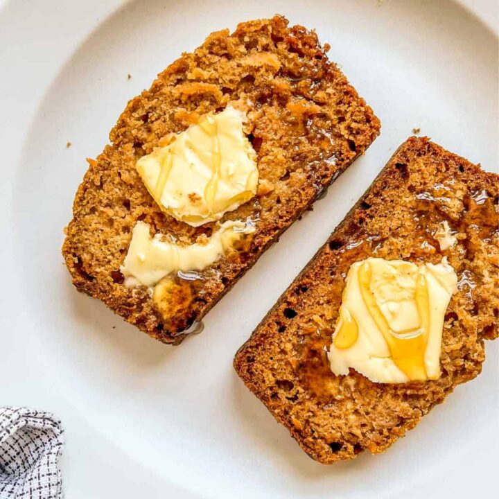 Cantaloupe bread with butter and honey on a white plate.