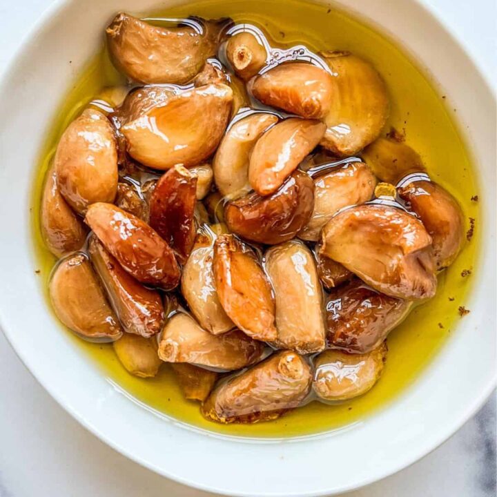 Garlic confit in a small white bowl.