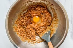 An egg and vanilla being cracked into the mixing bowl.