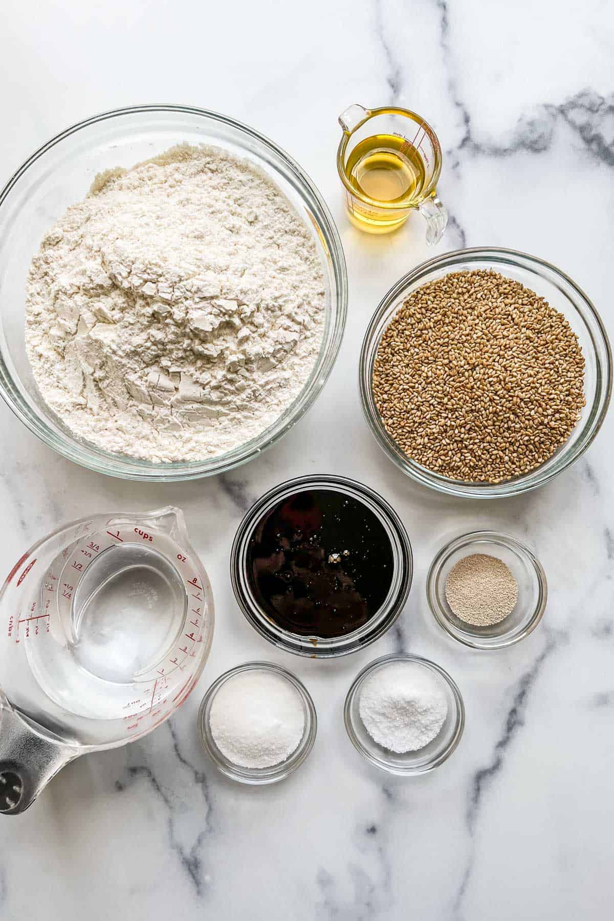 Bread flour, oil, sesame seeds, yeast, molasses, sugar, salt, and water.