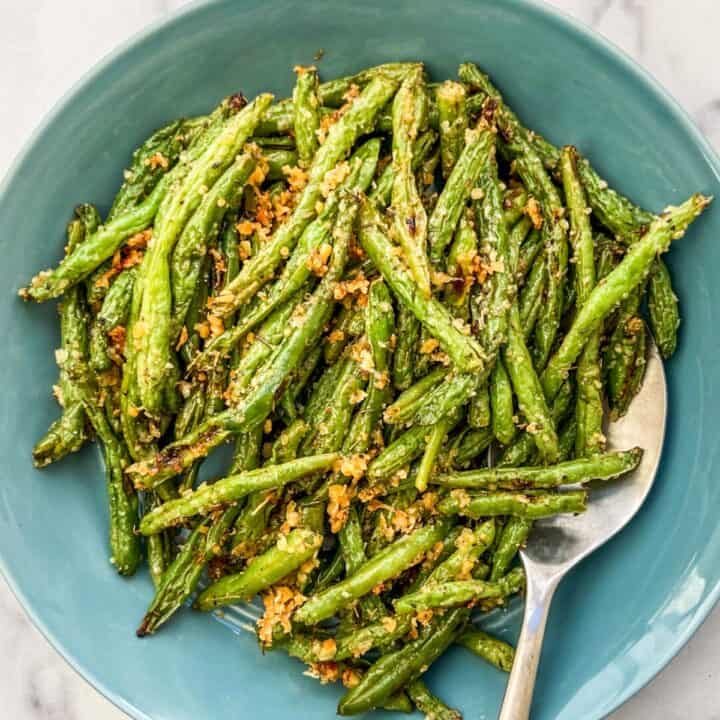 Roasted parmesan green beans in a blue bowl.