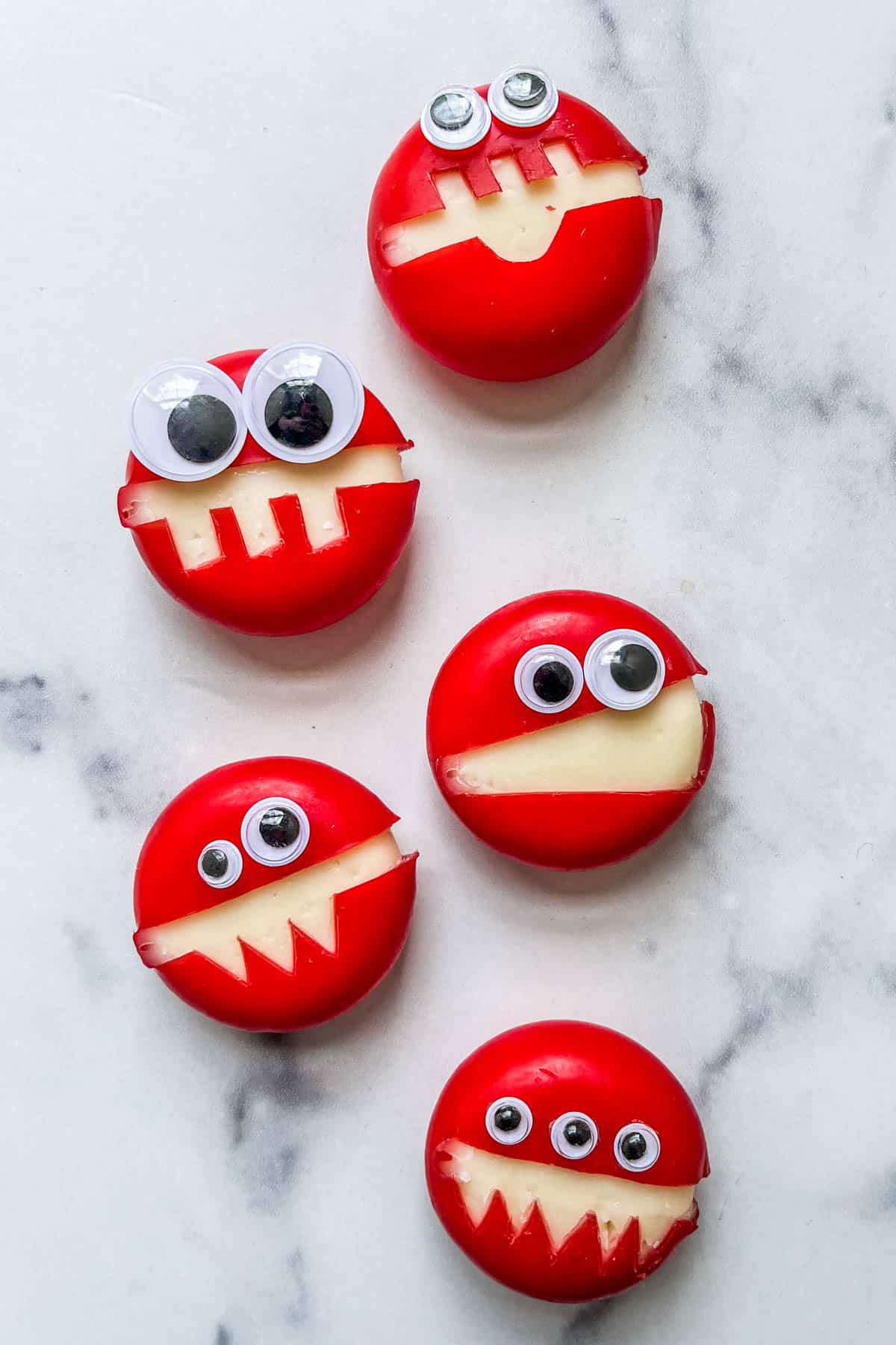Cheese monsters with googly eyes in a line.