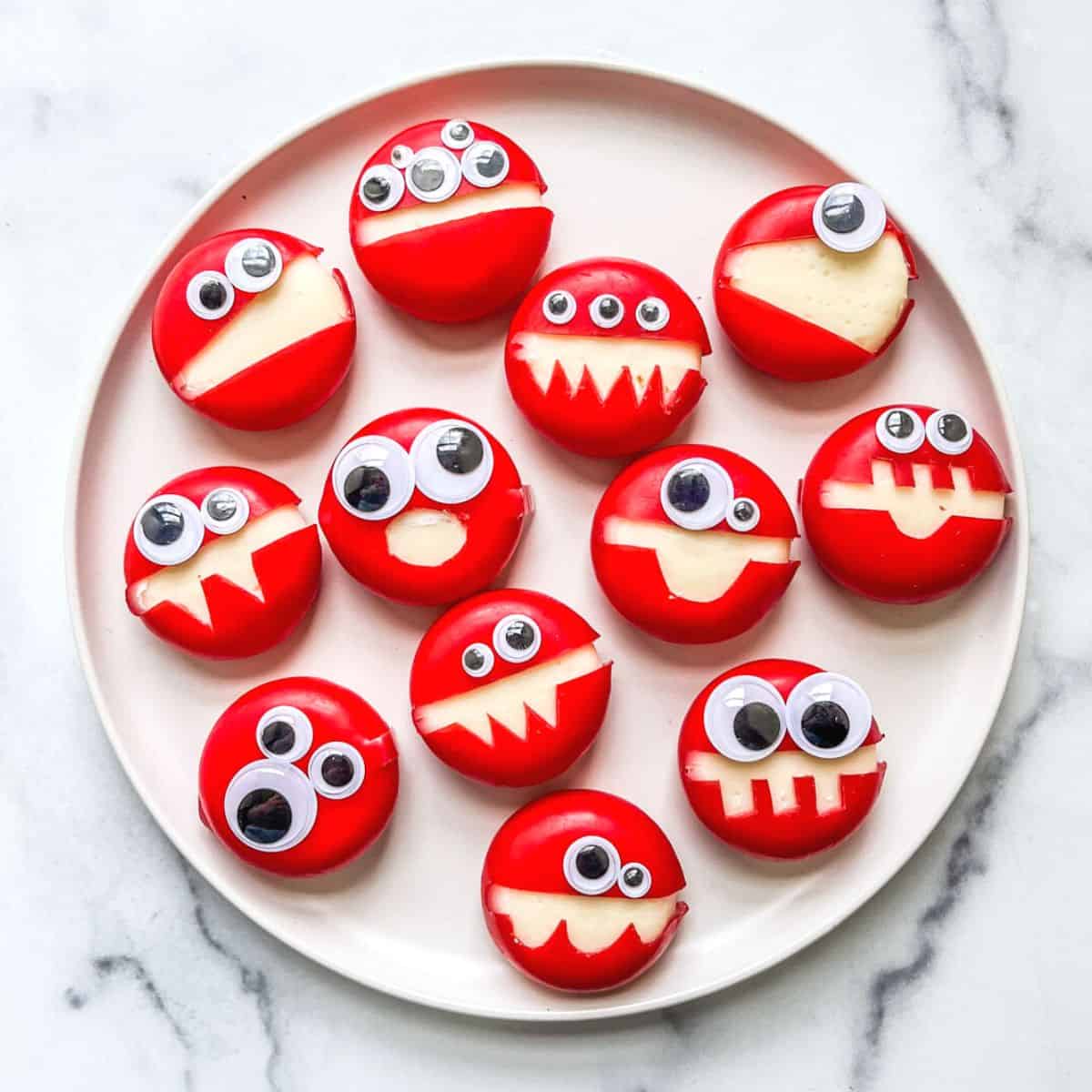 Babybel cheese monsters for Halloween on a plate.