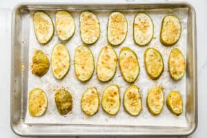 Roasted patty pan squash with parmesan on a baking sheet.