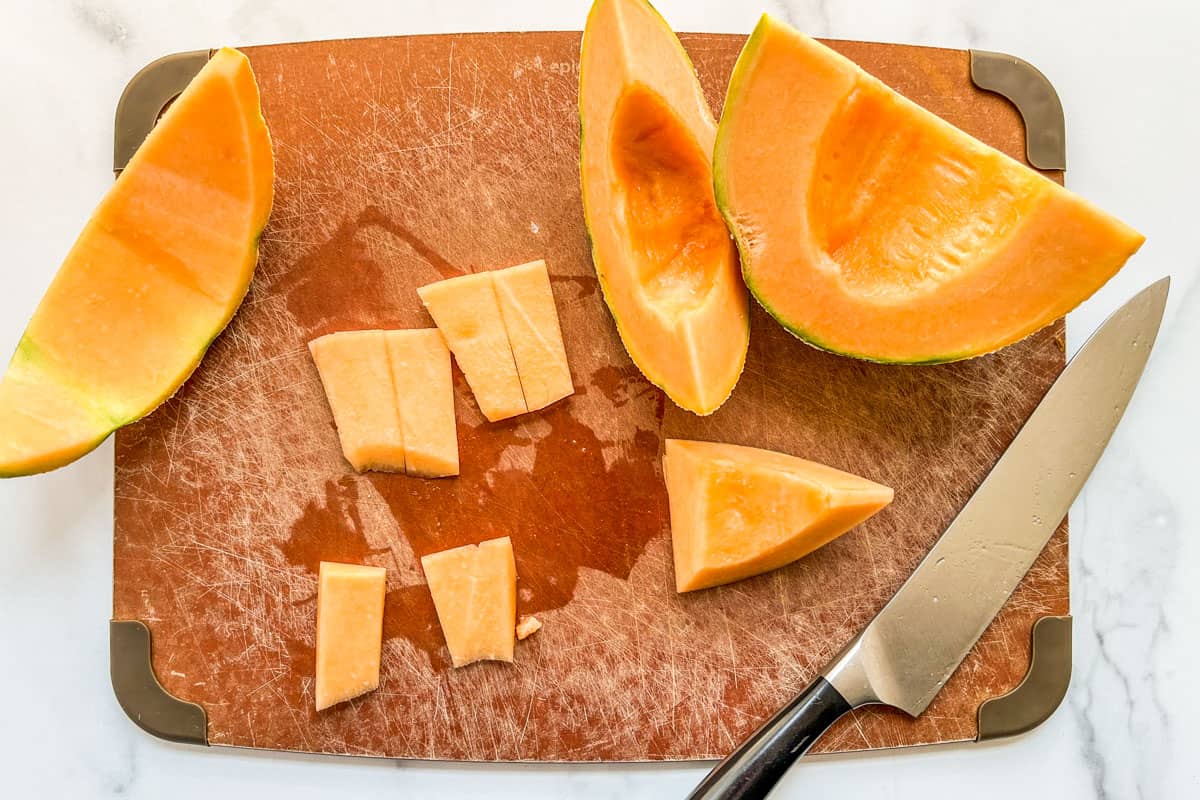 Slices of cantaloupe on a cutting board.