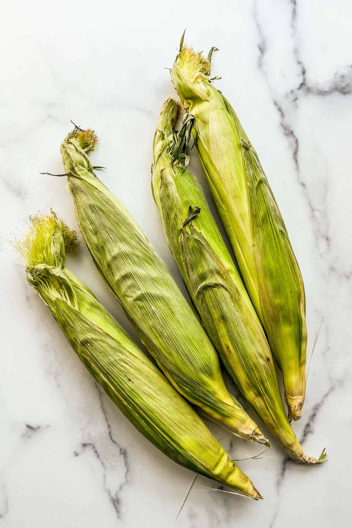 Four ears of fresh sweet corn.