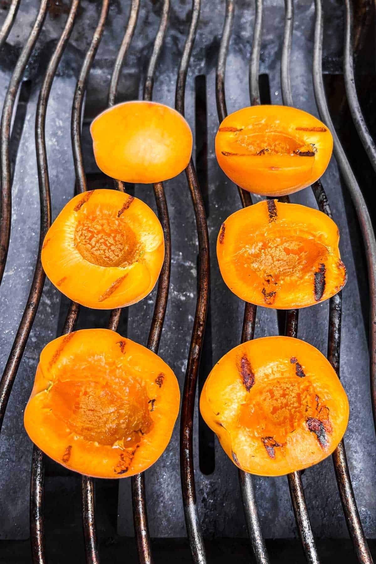 Grilling apricots on a grill.