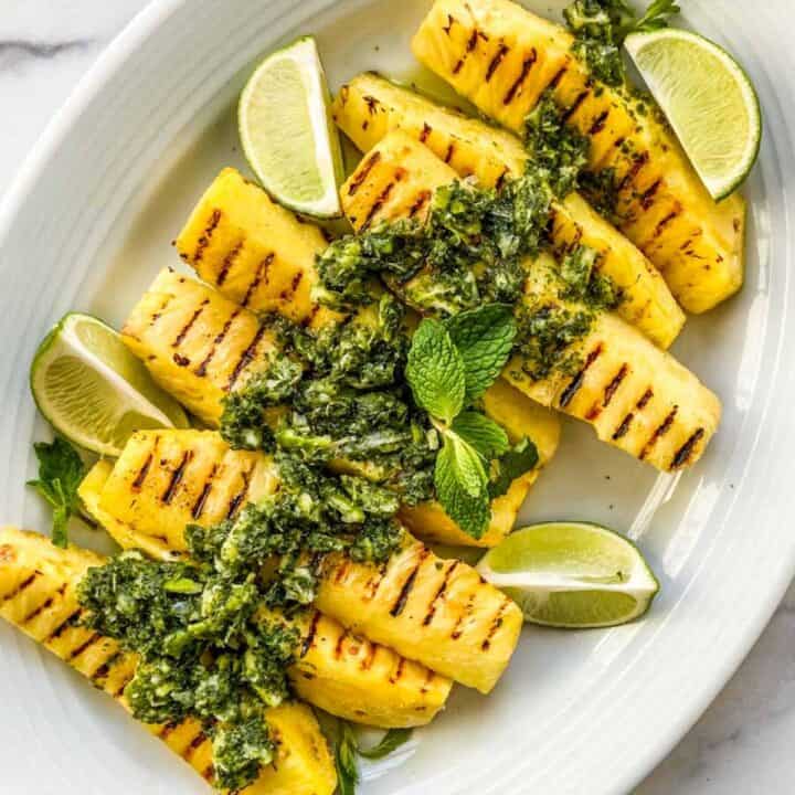 Grilled pineapple on a white platter.