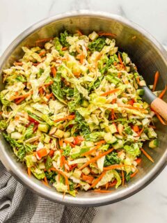A savoy cabbage salad recipe in a metal bowl with a spatula.