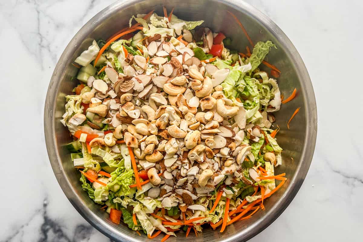 A savoy cabbage salad being mixed in a large bowl.