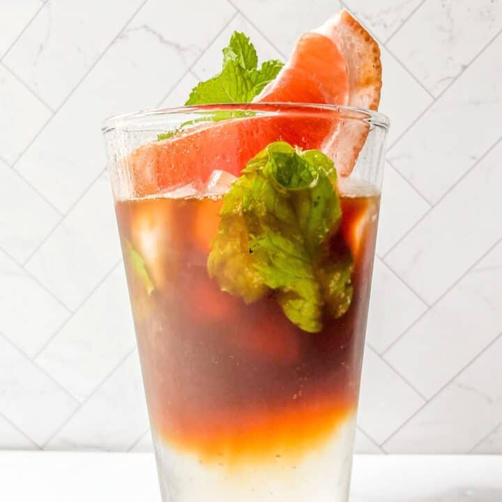 Sparkling Americano in a glass with mint and grapefruit.