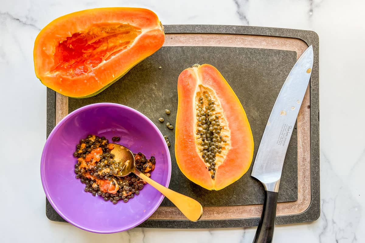 A papaya cut in half with the seeds scooped out.