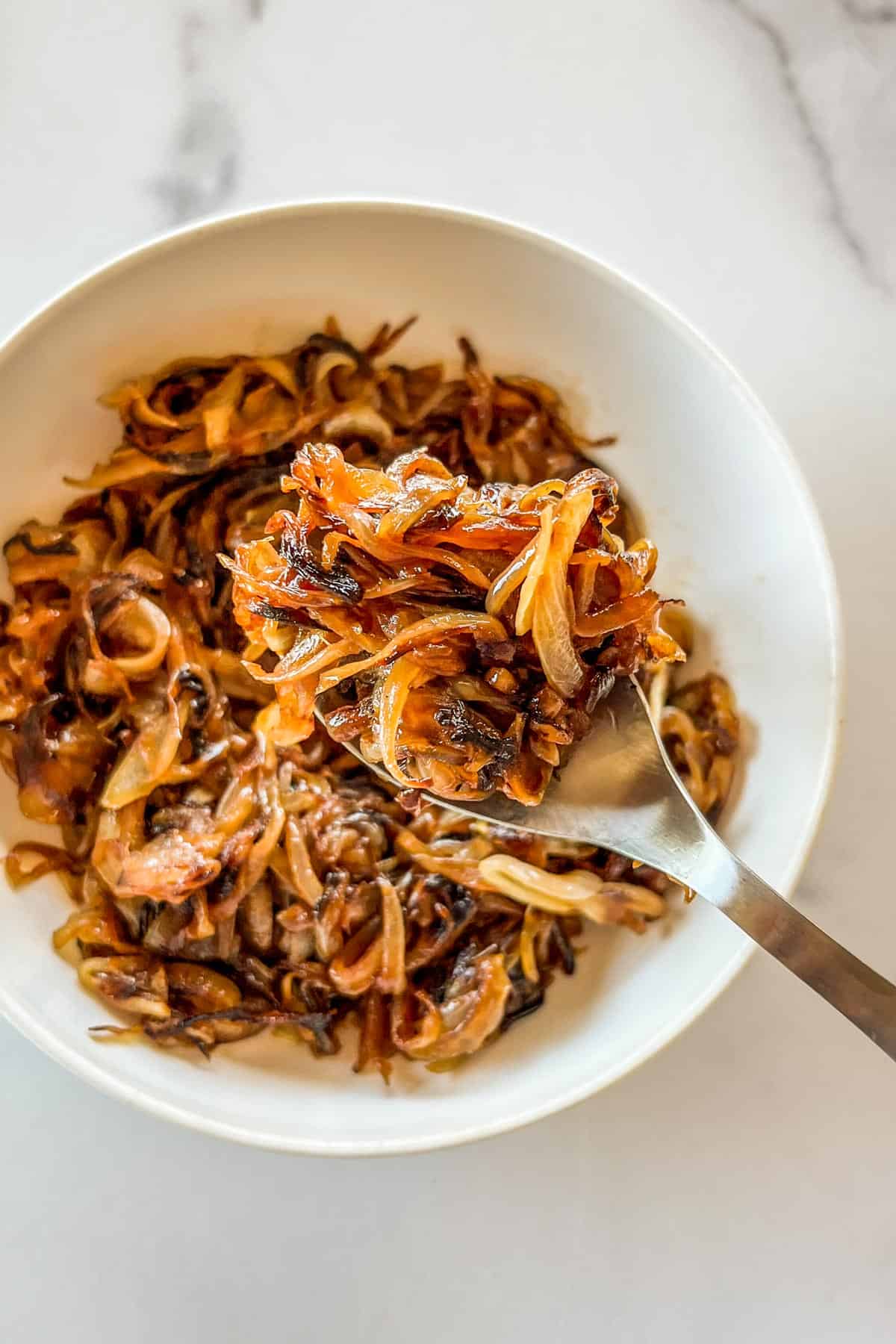 Caramelized onions in a bowl and spoon.