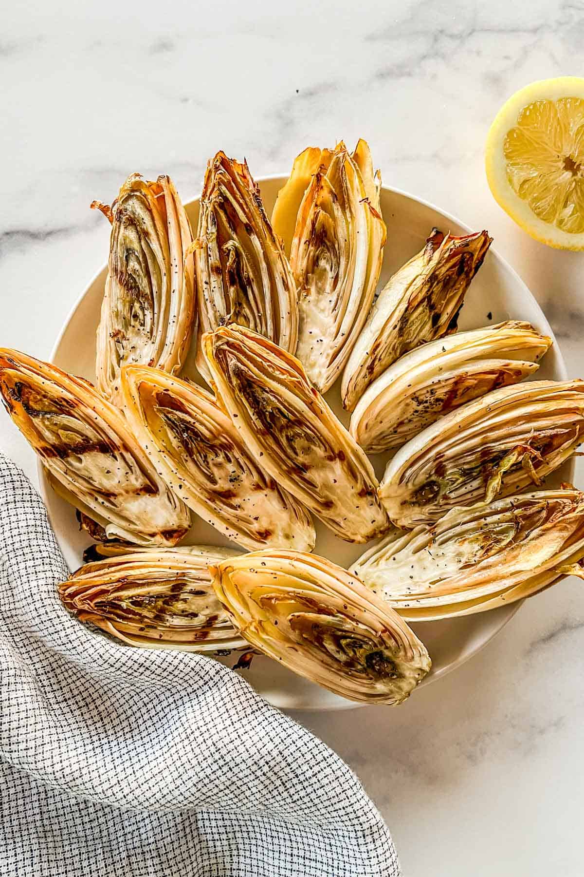 Grilled endives on a white plate.