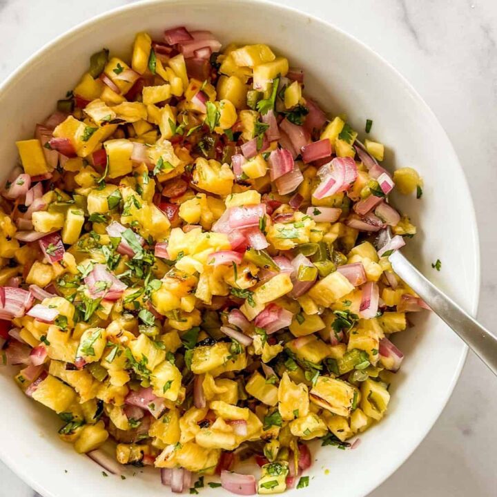 Grilled pineapple salsa with red onion in a bowl.
