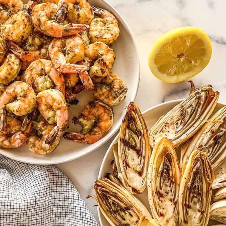 Grilled shrimp and endives on plates.