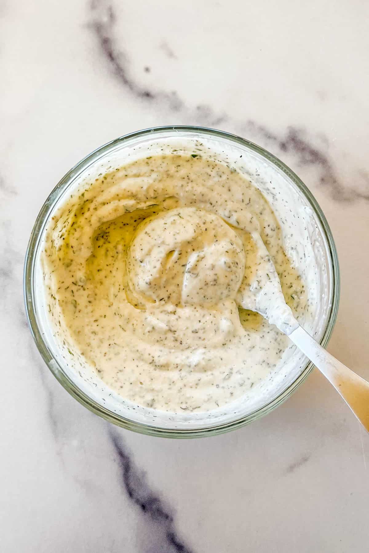 A homemade ranch dressing in a glass bowl.