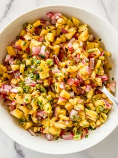 Grilled pineapple salsa in a bowl with a spoon.
