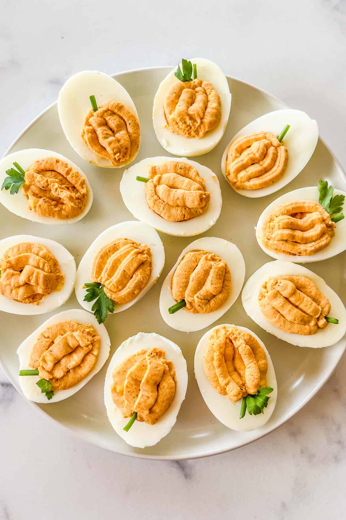 Pumpkin hardboiled eggs on a white plate.