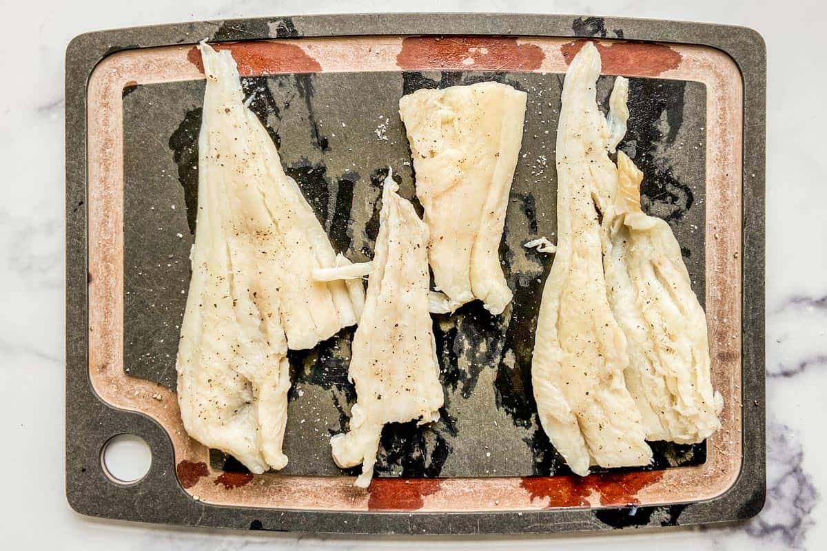 Fresh haddock fillets on a cutting board.