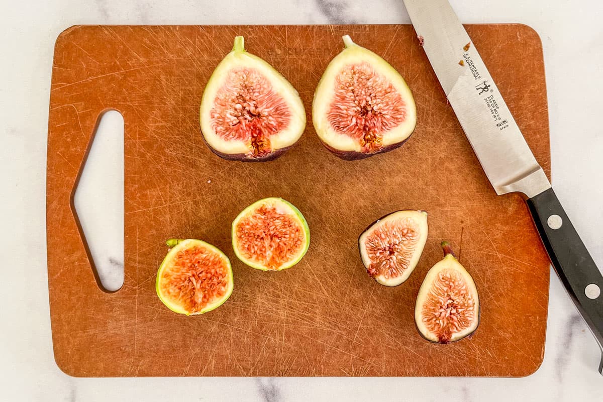 Figs sliced in half on a cutting board.