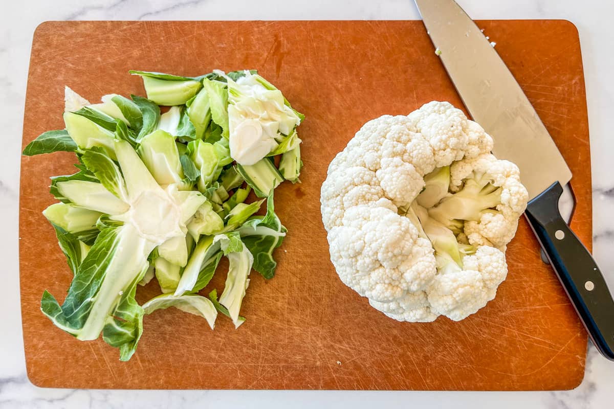 Slicing cauliflower on a cutting board.