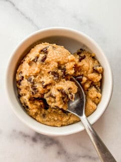 Healthy edible cookie dough with chocolate chips in a ramekin with a spoon.