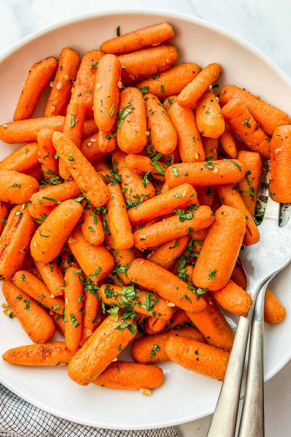 Roasted baby carrots topped with chopped parsley.