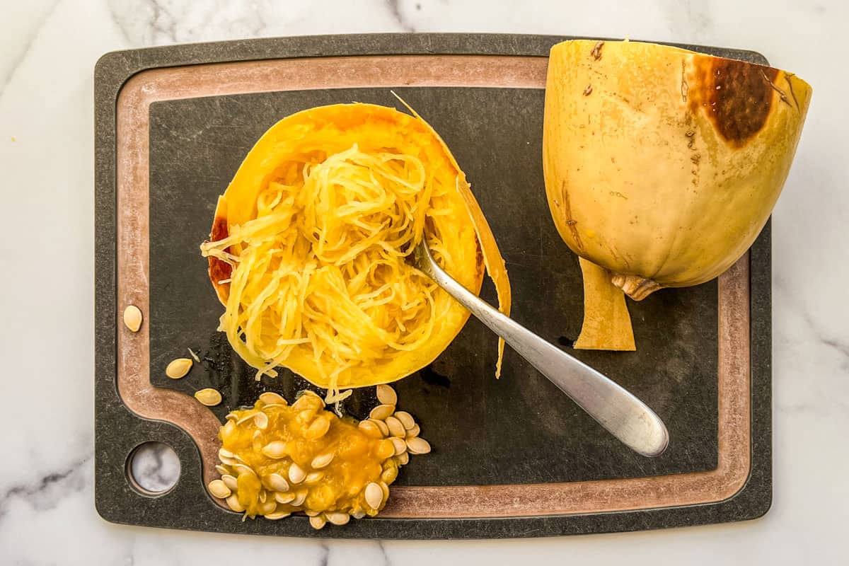 Pulling the strands of the roasted spaghetti squash away from the skin.