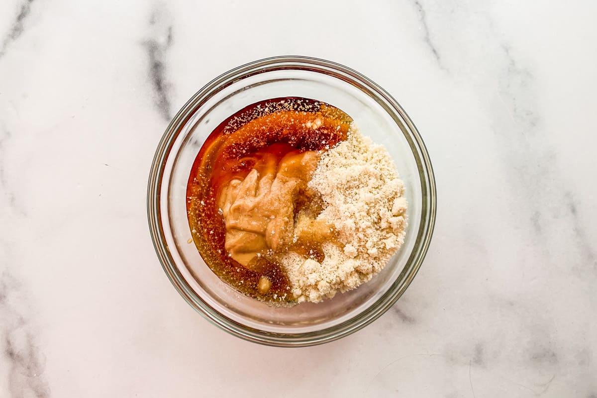 Maple syrup, peanut butter, and almond flour in a mixing bowl.