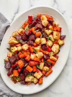 Oven roasted root vegetables on a white serving platter.