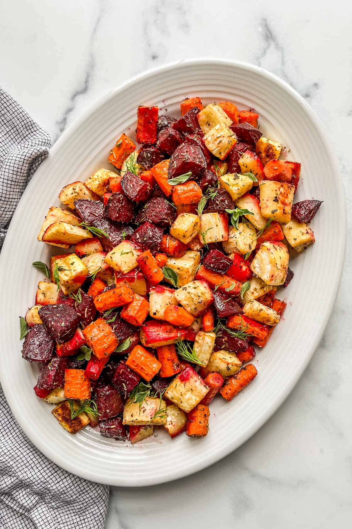 Oven roasted root vegetables on a white serving platter.