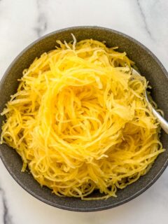 Roasted spaghetti squash noodles in a black bowl.