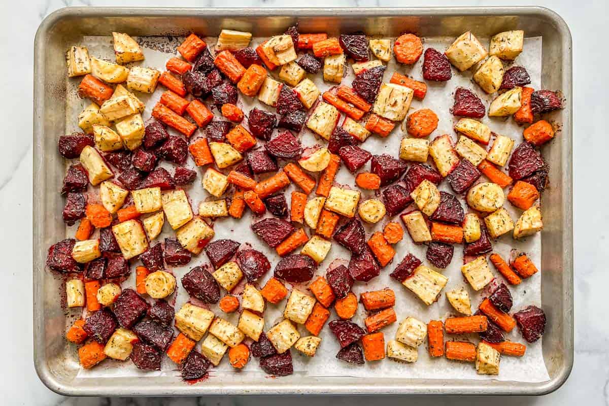 Root vegetables on a baking sheet after coming out of the oven.