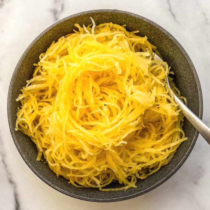 Roasted spaghetti squash noodles in a black bowl.