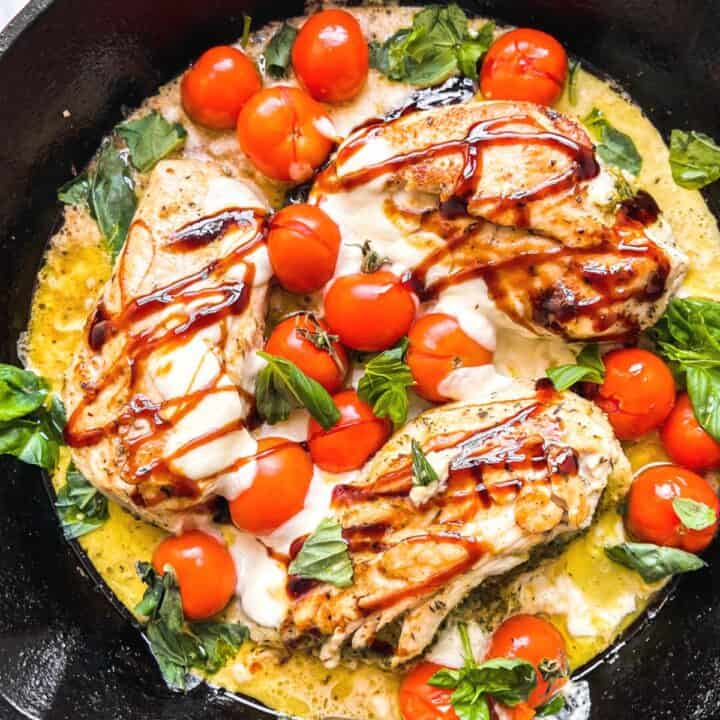 Baked caprese chicken in a cast iron pan.