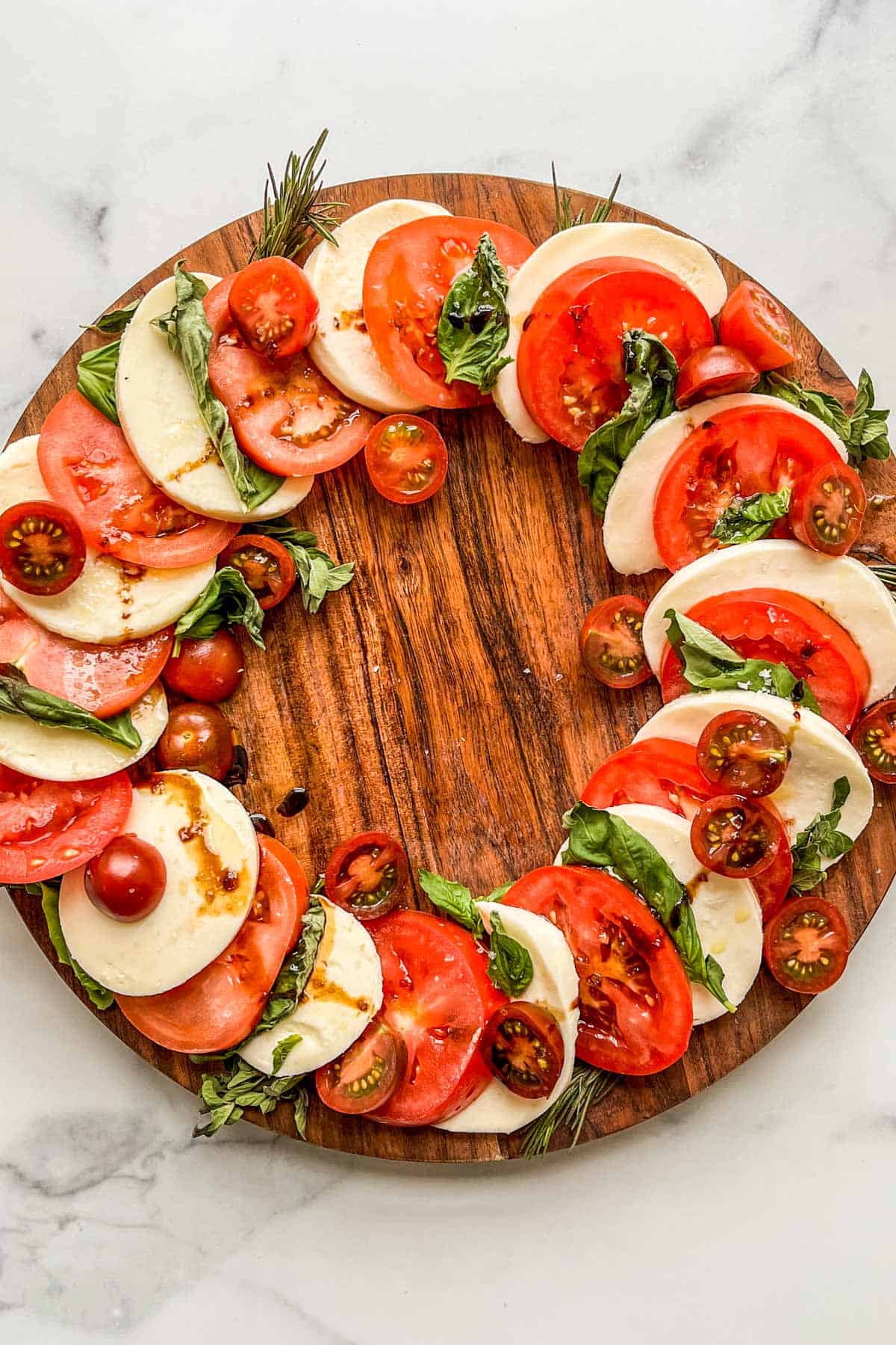 A caprese wreath with tomatoes, mozzarella, and herbs.