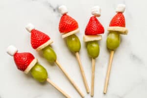 Grinch fruit skewers with grapes, bananas, strawberries, and mini marshmellows.