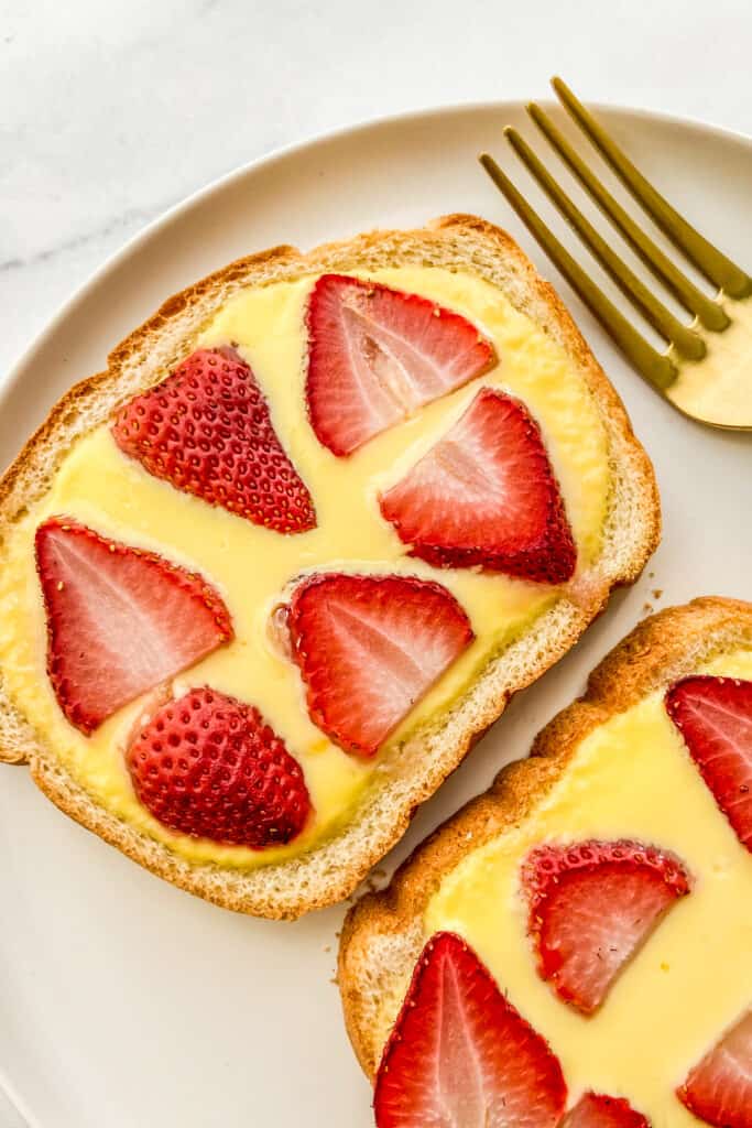 Yogurt toast with strawberries on a plate with a fork.