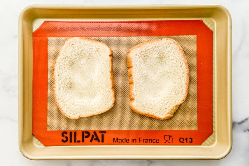 Two pieces of bread on a baking sheet.