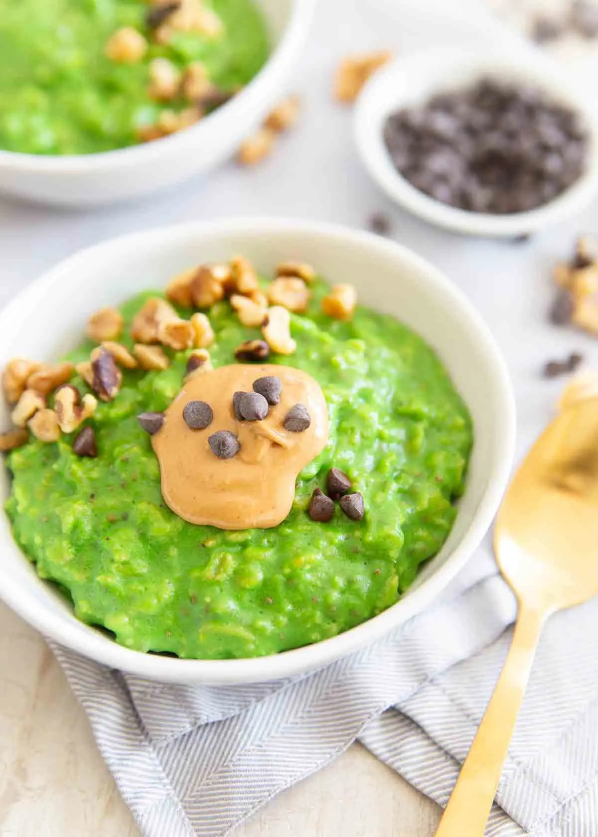 Green oatmeal in a white bowl.