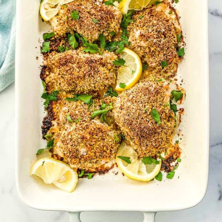 Lemon pepper chicken thighs in a baking dish.