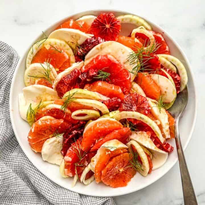 An orange fennel salad in a large white serving bowl.