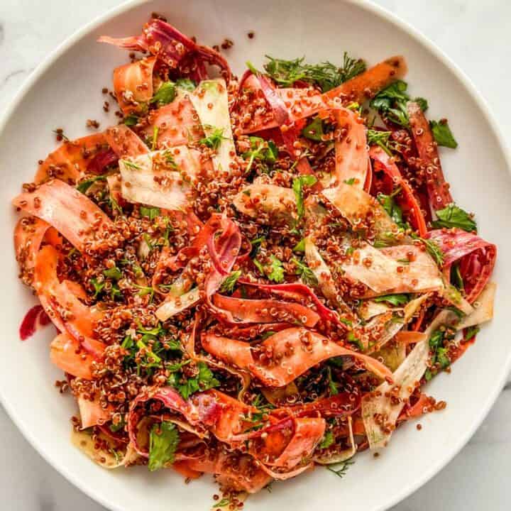 A rainbow carrot salad with quinoa and feta in a bowl.